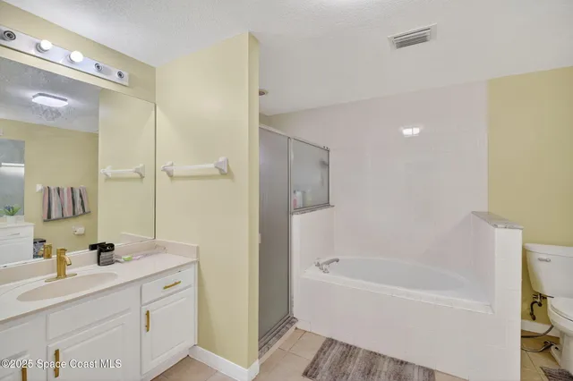 a bathroom with a bathtub shower sink vanity and mirror