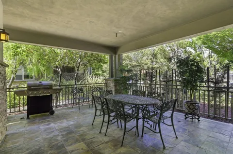 a patio with yard glass top table and chairs
