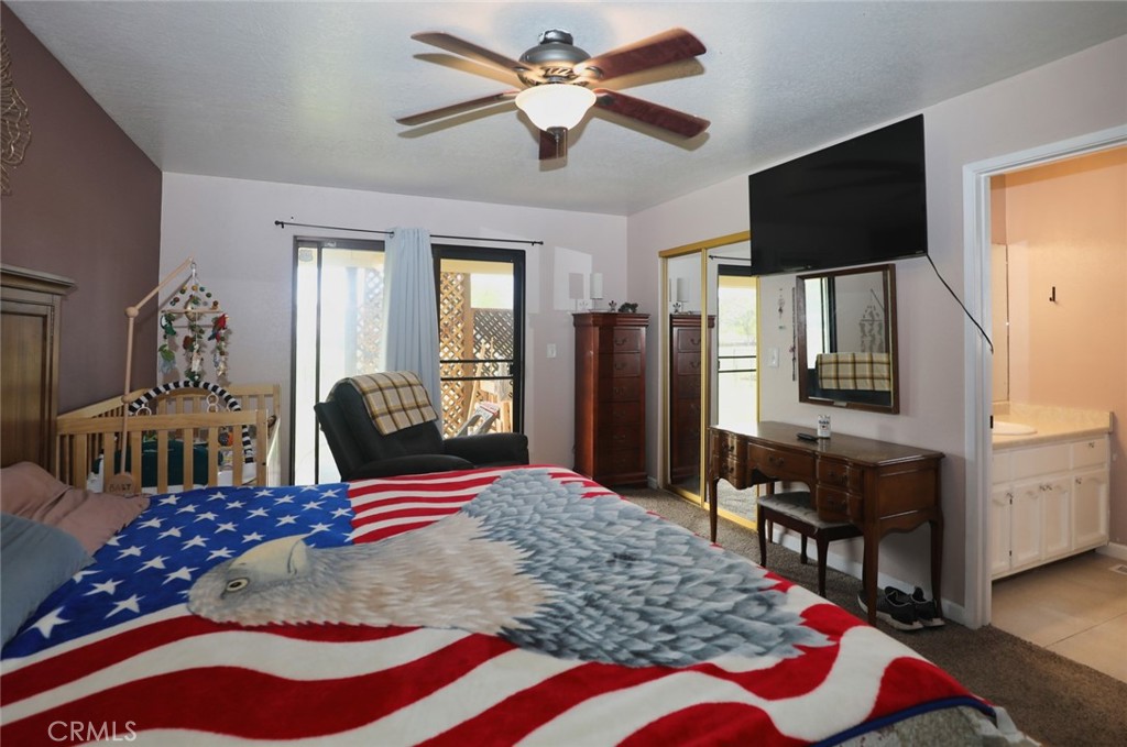 19425 Old Creek Road Hidden Valley Lake, CA 95467 - Photo 22 of 41 a bedroom with a bed and flat screen tv