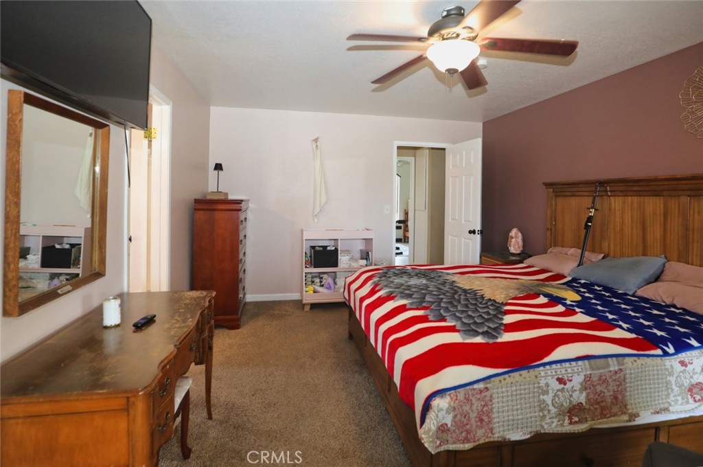 19425 Old Creek Road Hidden Valley Lake, CA 95467 - Photo 23 of 41 a bedroom with a bed and a chandelier