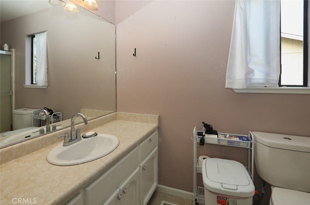 19425 Old Creek Road Hidden Valley Lake, CA 95467 - Photo 24 of 41 a bathroom with a toilet a sink and a mirror