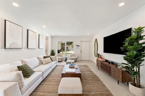 a living room with furniture potted plant and a flat screen tv