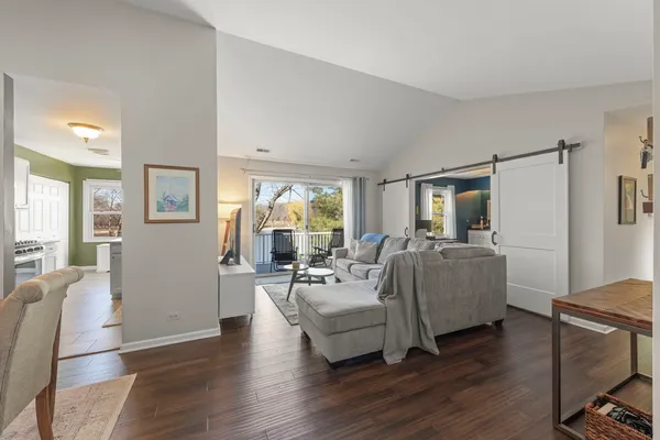 a living room with furniture wooden floor and a large window