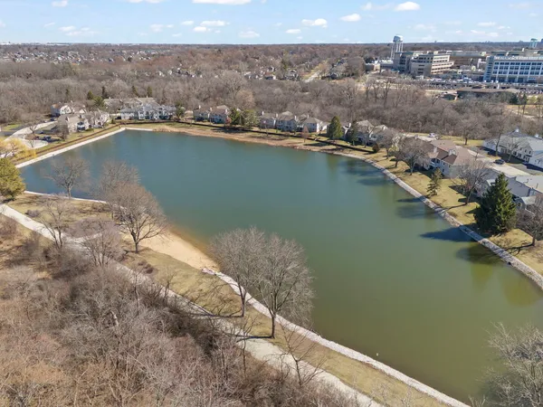 an aerial view of residential houses with outdoor space and lake view