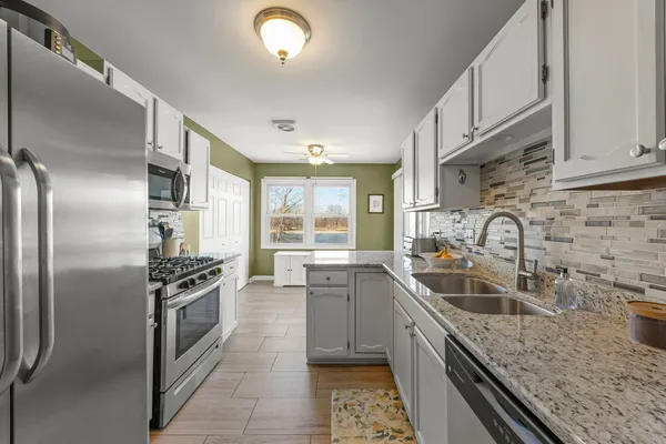 a kitchen with stainless steel appliances granite countertop a sink stove and refrigerator