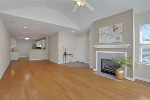 a view of kitchen and empty room with wooden floor