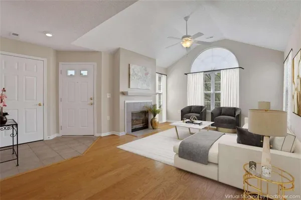 a living room with furniture a fireplace and a chandelier
