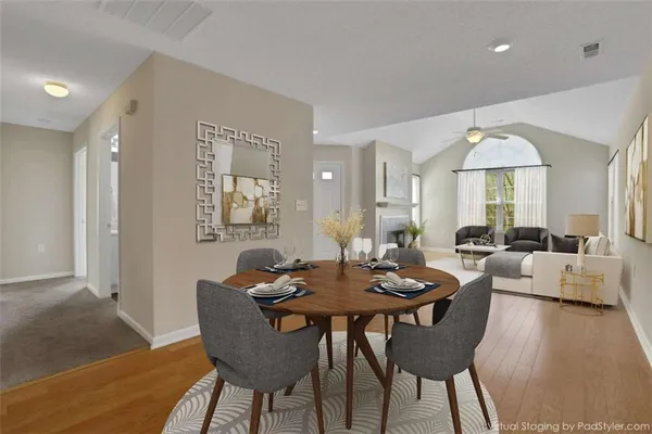 a view of a a dining room with furniture window and wooden floor