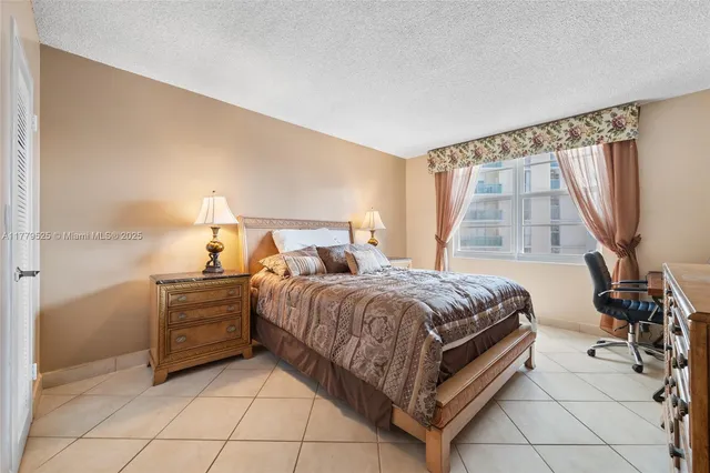 a bedroom with a bed and a flat tv screen on the dresser
