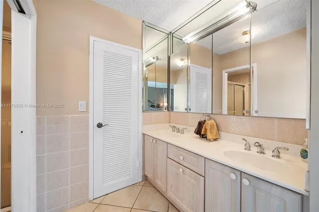 a bathroom with a double vanity sink mirror and shower