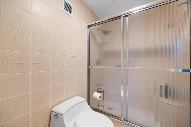 a bathroom with a toilet and a shower