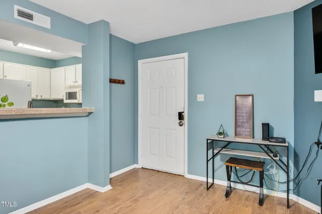 a workspace room with wooden floor and furniture