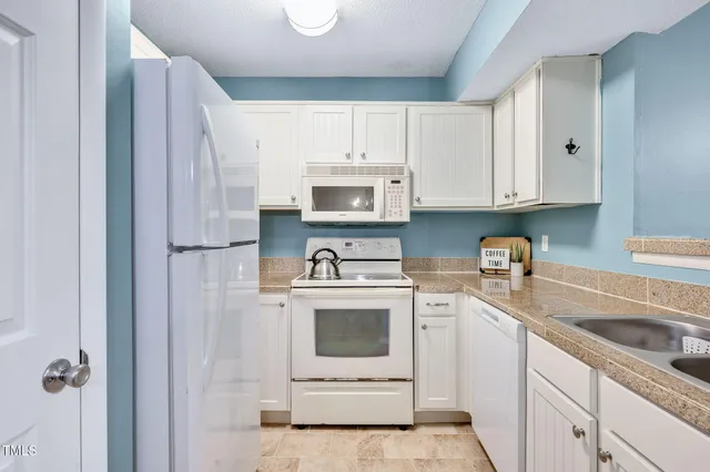 a kitchen with cabinets stainless steel appliances and sink