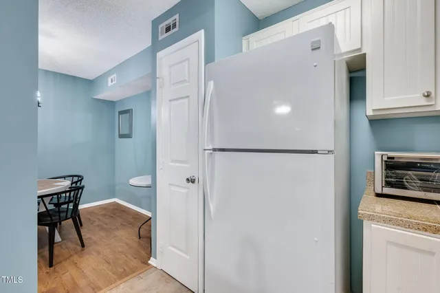 a view of a kitchen with a refrigerator and cabinets