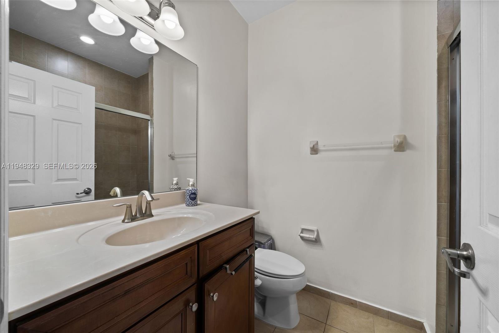 8658 Northwest 99th Path Doral, FL 33178 - Photo 14 of 46 a bathroom with a sink a toilet and a mirror
