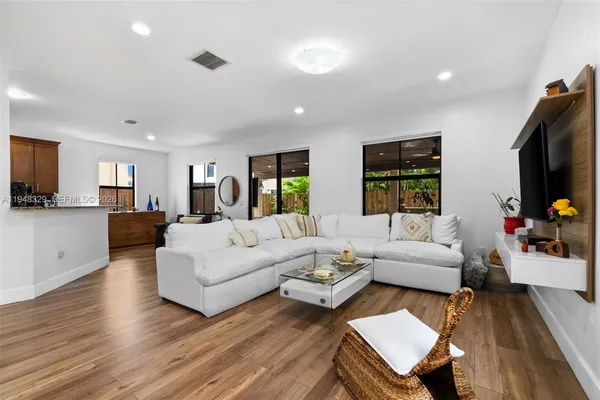 a living room with furniture flat screen tv and window