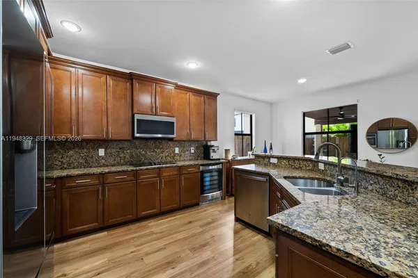 a kitchen with stainless steel appliances granite countertop a sink stove and refrigerator