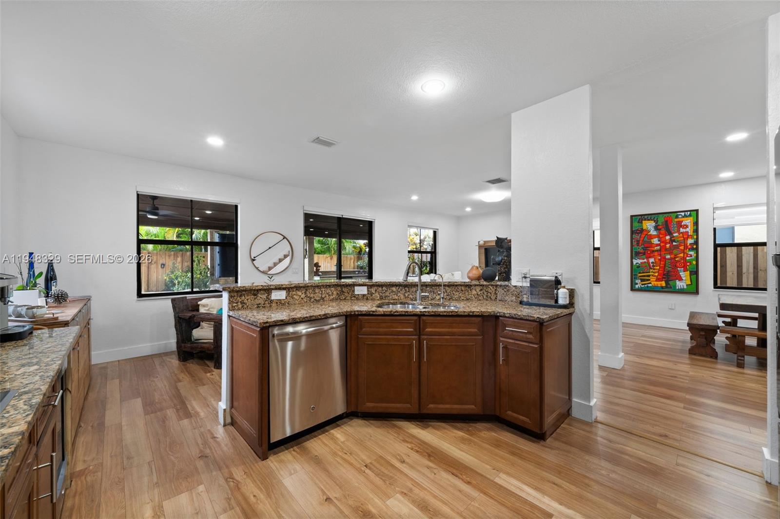 8658 Northwest 99th Path Doral, FL 33178 - Photo 43 of 46 a kitchen with stainless steel appliances granite countertop wooden cabinets a sink a stove a dining table and chairs