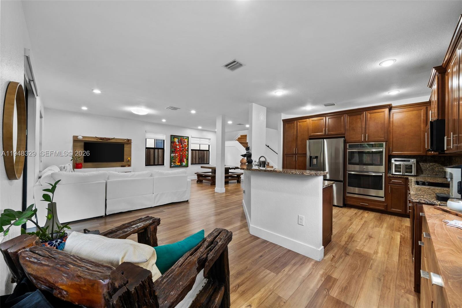 8658 Northwest 99th Path Doral, FL 33178 - Photo 44 of 46 a living room with furniture kitchen view and a flat screen tv