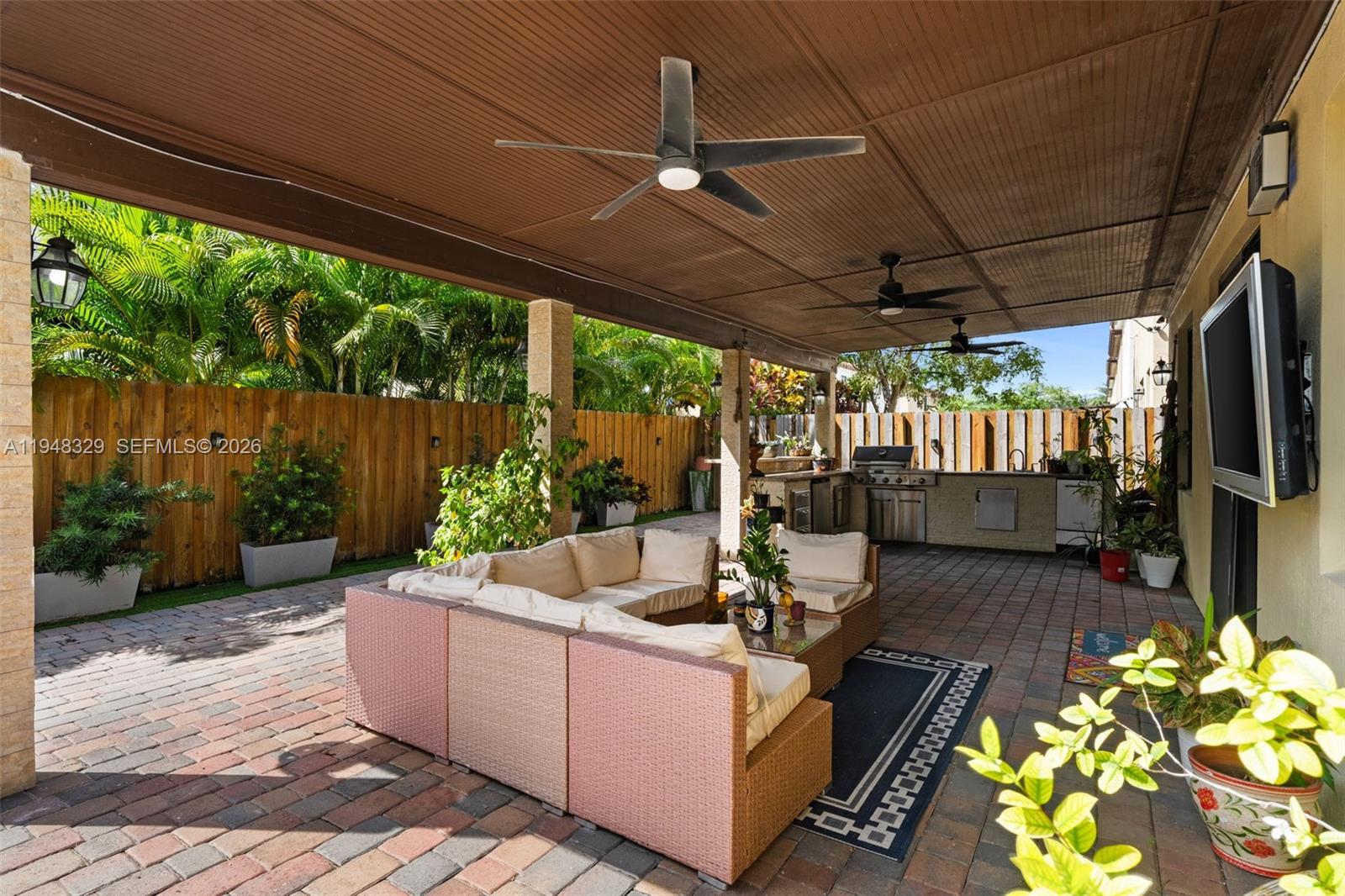 8658 Northwest 99th Path Doral, FL 33178 - Photo 5 of 46 a view of a patio with couches chairs potted plants and floor to ceiling window