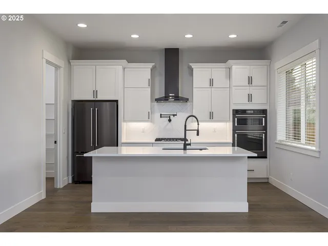 a kitchen with kitchen island a sink stainless steel appliances and window
