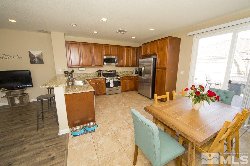 10898 Oakhaven Drive Reno, NV 89521 - Photo 5 of 19 a kitchen with sink refrigerator dining table and chairs