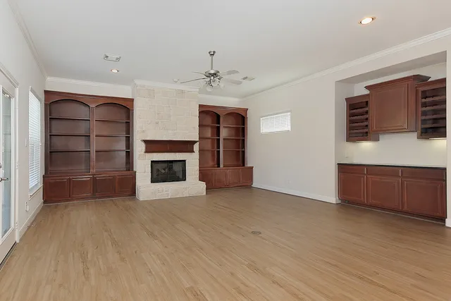 a view of a livingroom with a fireplace a ceiling fan and window