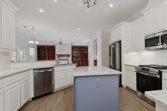 a kitchen with stainless steel appliances granite countertop a sink stove and refrigerator