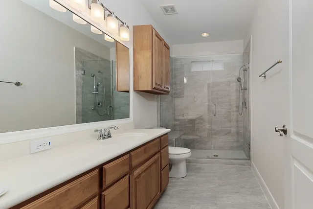 a bathroom with a double vanity sink toilet and shower