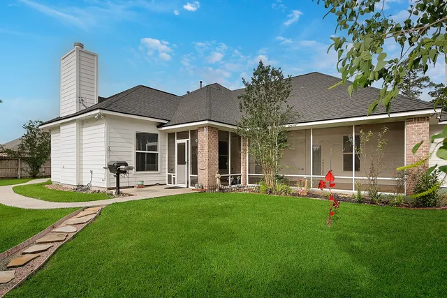 a view of a house with a yard and sitting area