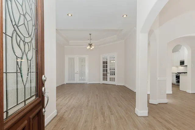 a view of an empty room with wooden floor and a window
