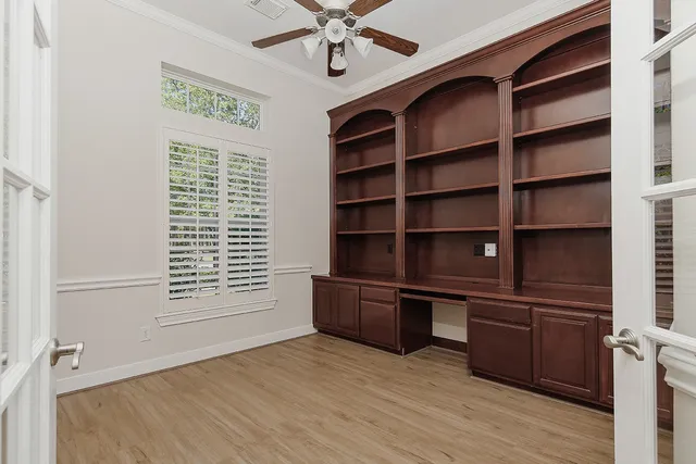 a view of an empty room with a window and wooden floor