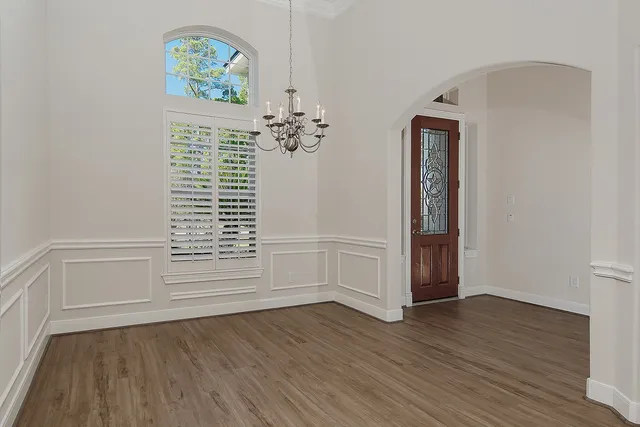 an empty room with wooden floor and window