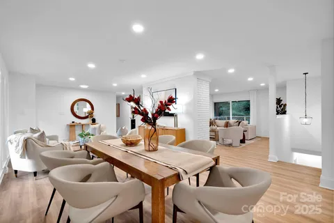 a living room with furniture and a dining table with wooden floor