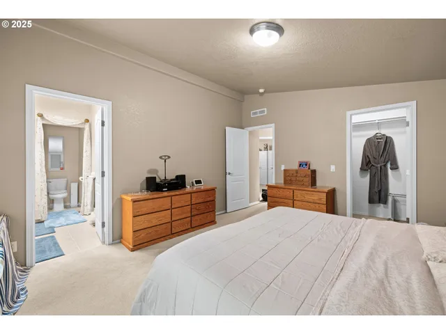 a large bedroom with a bed and a large mirror