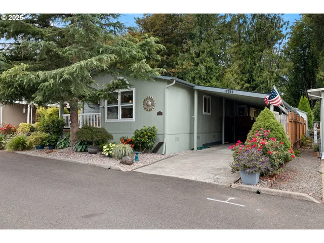 a front view of a house with a yard and potted plants