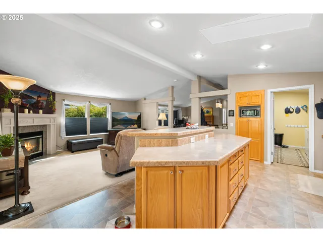 a living room with furniture a fireplace and a kitchen view