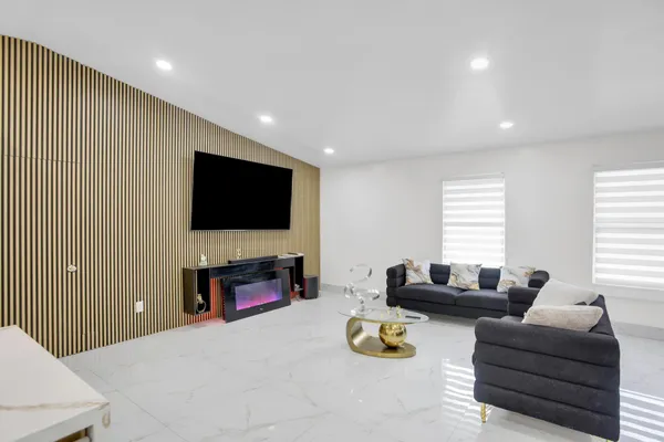 a view of a livingroom with wooden floor and a hallway