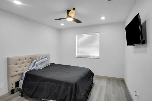a view of an empty room with a window and a kitchen