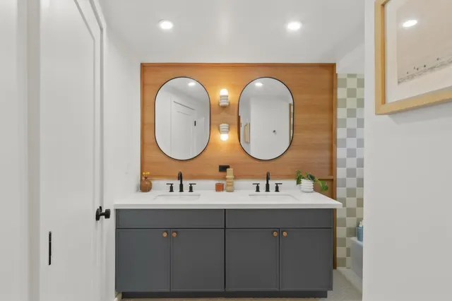 a spacious bedroom with a bed and painting on the wall