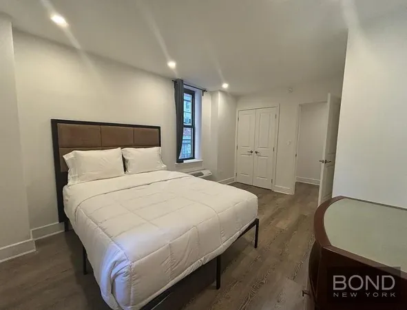 a bedroom with a bed and a night stand