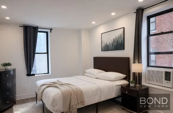 a bedroom with a bed and painting on the wall