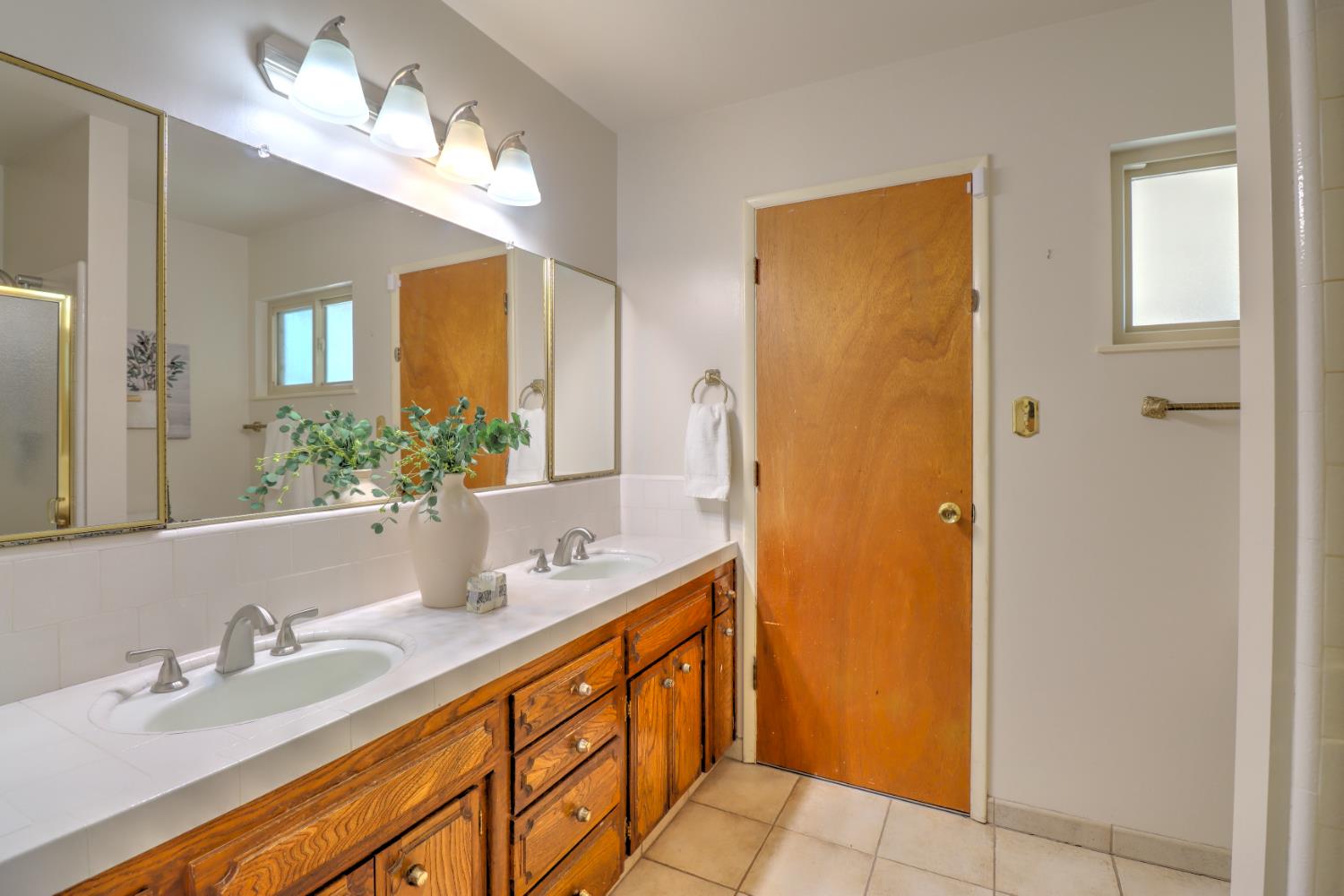 6265 North Colonial Avenue Fresno, CA 93704 - Photo 16 of 22 a bathroom with a double vanity sink and a mirror