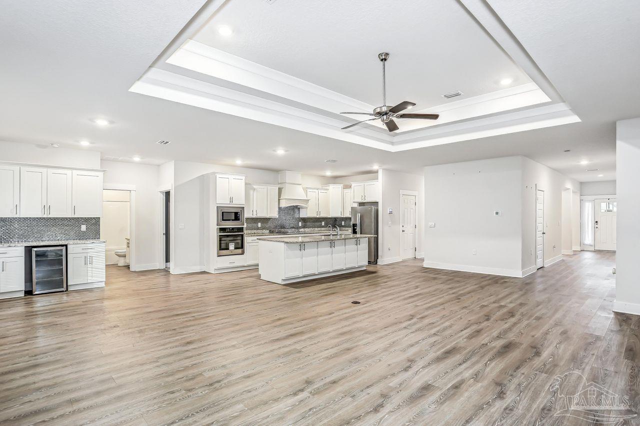 5665 Blake Lane Pace, FL 32571 - Photo 16 of 44 a view of an empty room with kitchen appliances and a ceiling fan