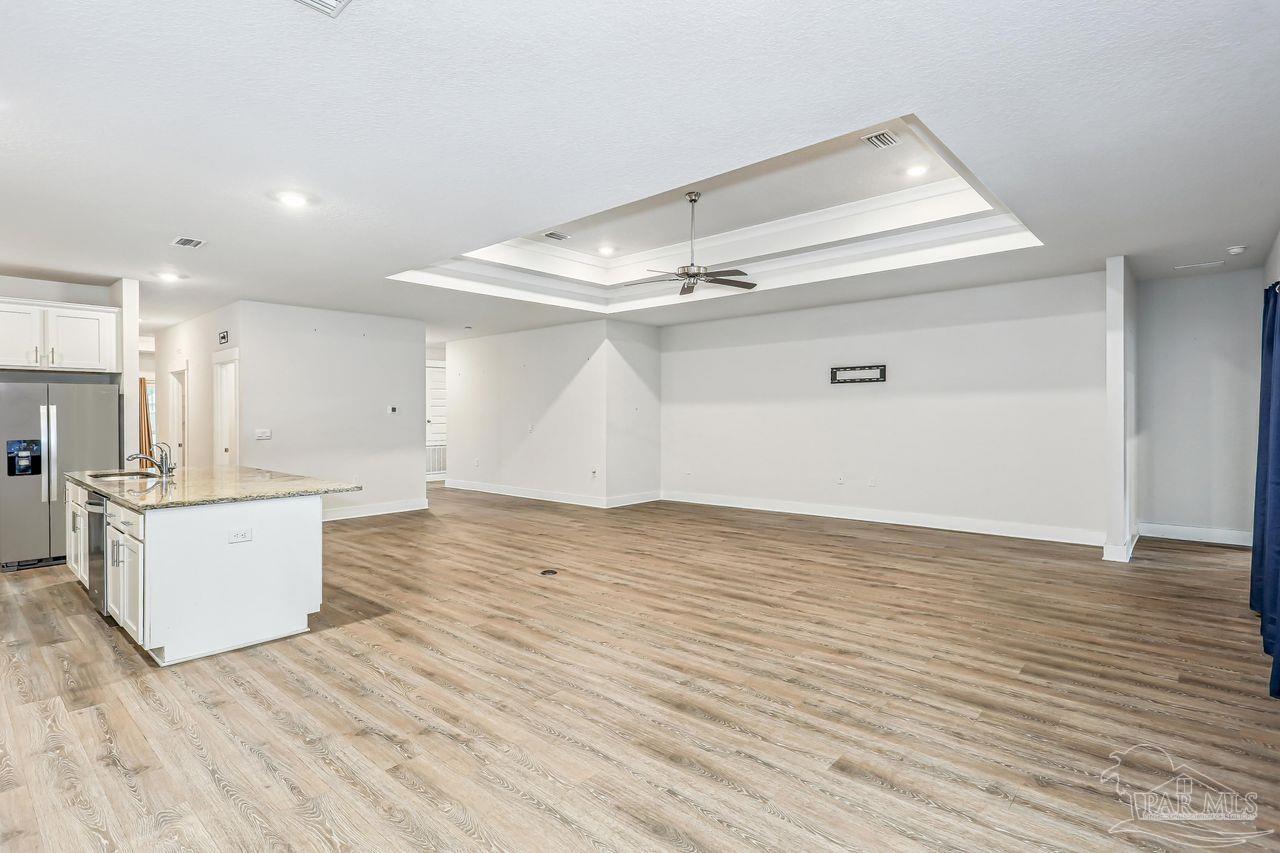 5665 Blake Lane Pace, FL 32571 - Photo 18 of 44 a view of kitchen and empty room with wooden floor