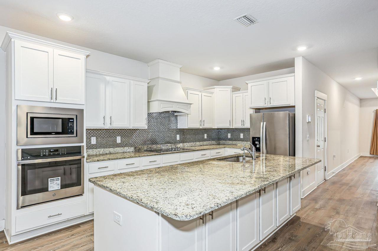 5665 Blake Lane Pace, FL 32571 - Photo 19 of 44 a kitchen with stainless steel appliances granite countertop a sink stove and refrigerator