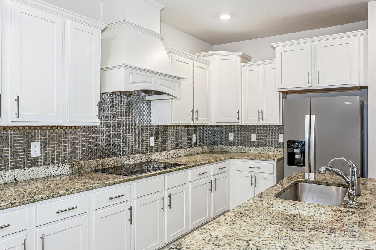 5665 Blake Lane Pace, FL 32571 - Photo 21 of 44 a kitchen with granite countertop a sink stainless steel appliances and cabinets