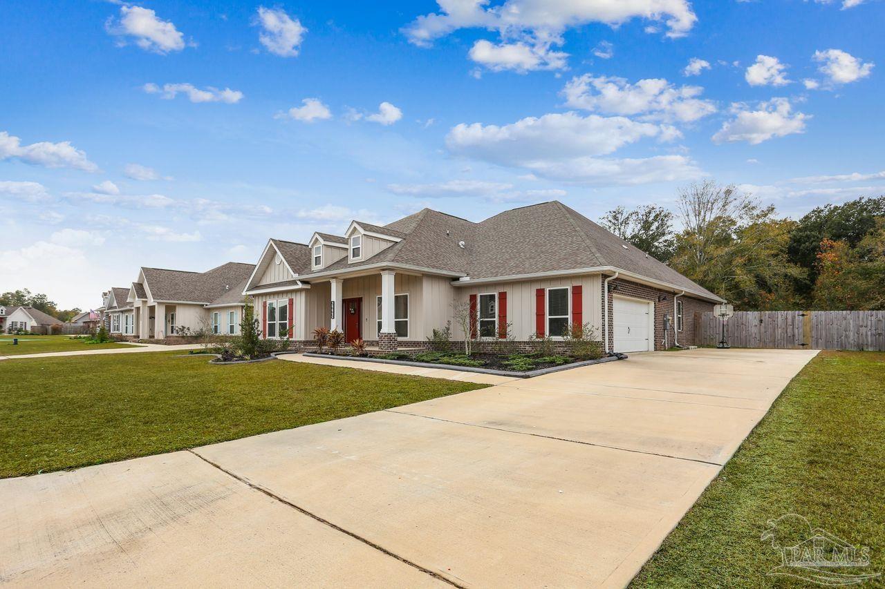 5665 Blake Lane Pace, FL 32571 - Photo 3 of 44 a front view of a house with a garden