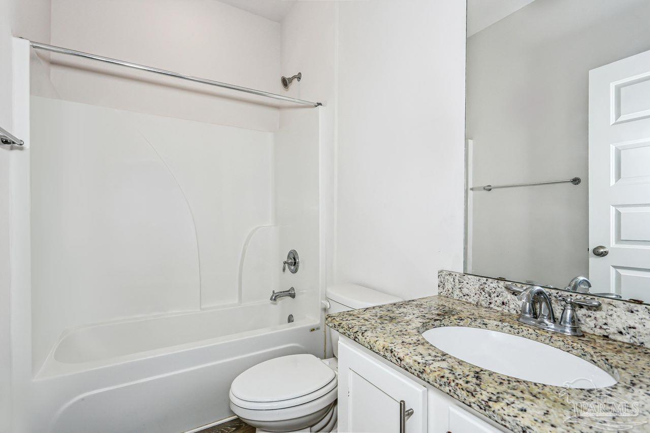 5665 Blake Lane Pace, FL 32571 - Photo 36 of 44 a bathroom with a granite countertop sink toilet and shower