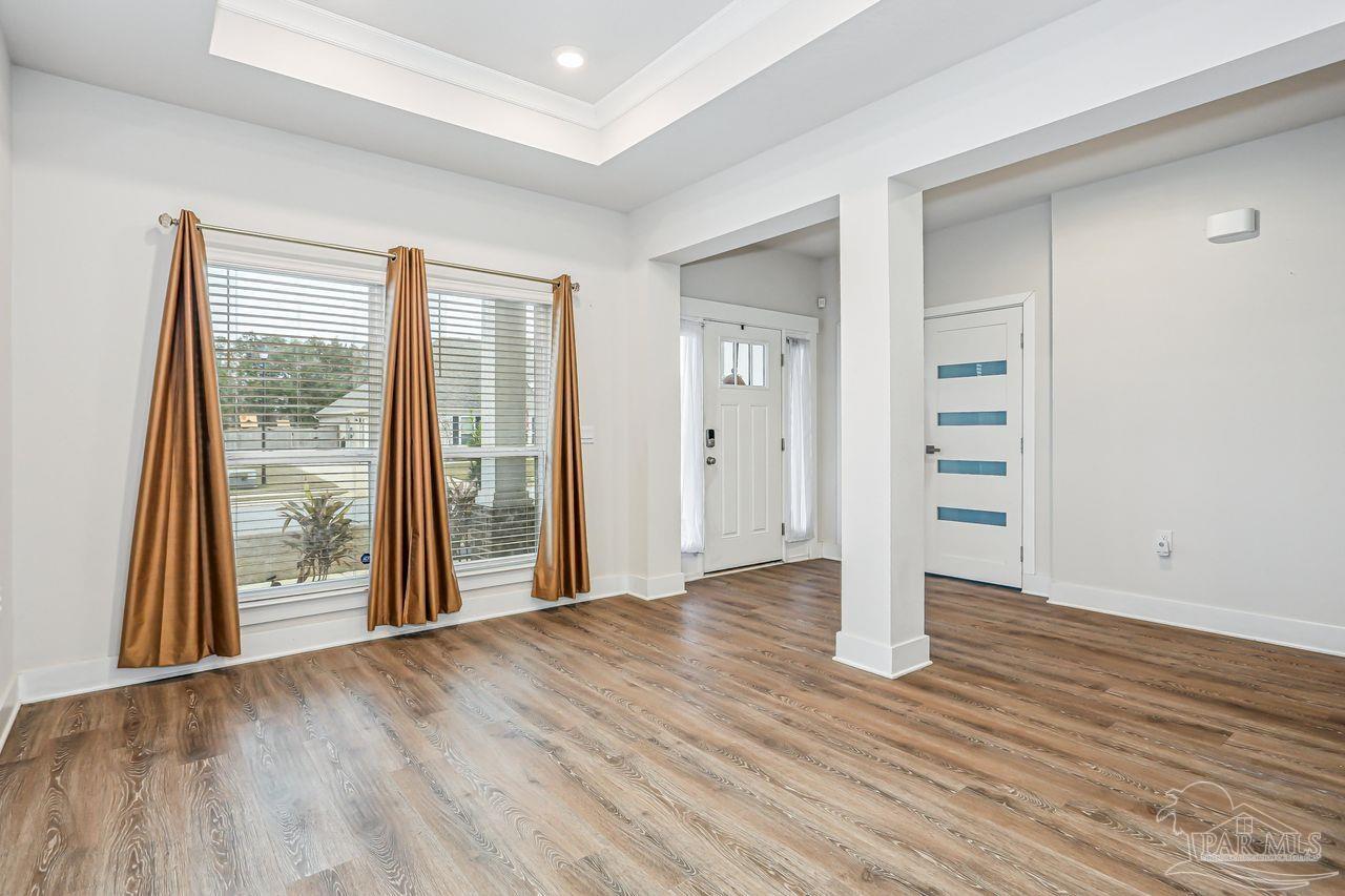 5665 Blake Lane Pace, FL 32571 - Photo 9 of 44 an empty room with wooden floor and windows